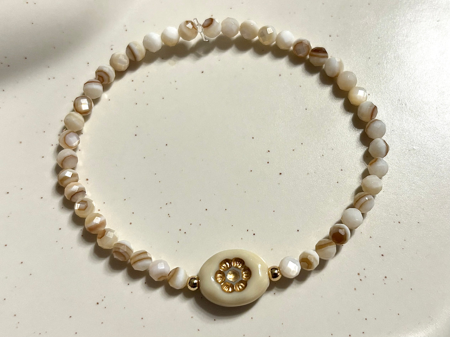 Armband aus natürlichen Muschelperlen und goldenen Details
