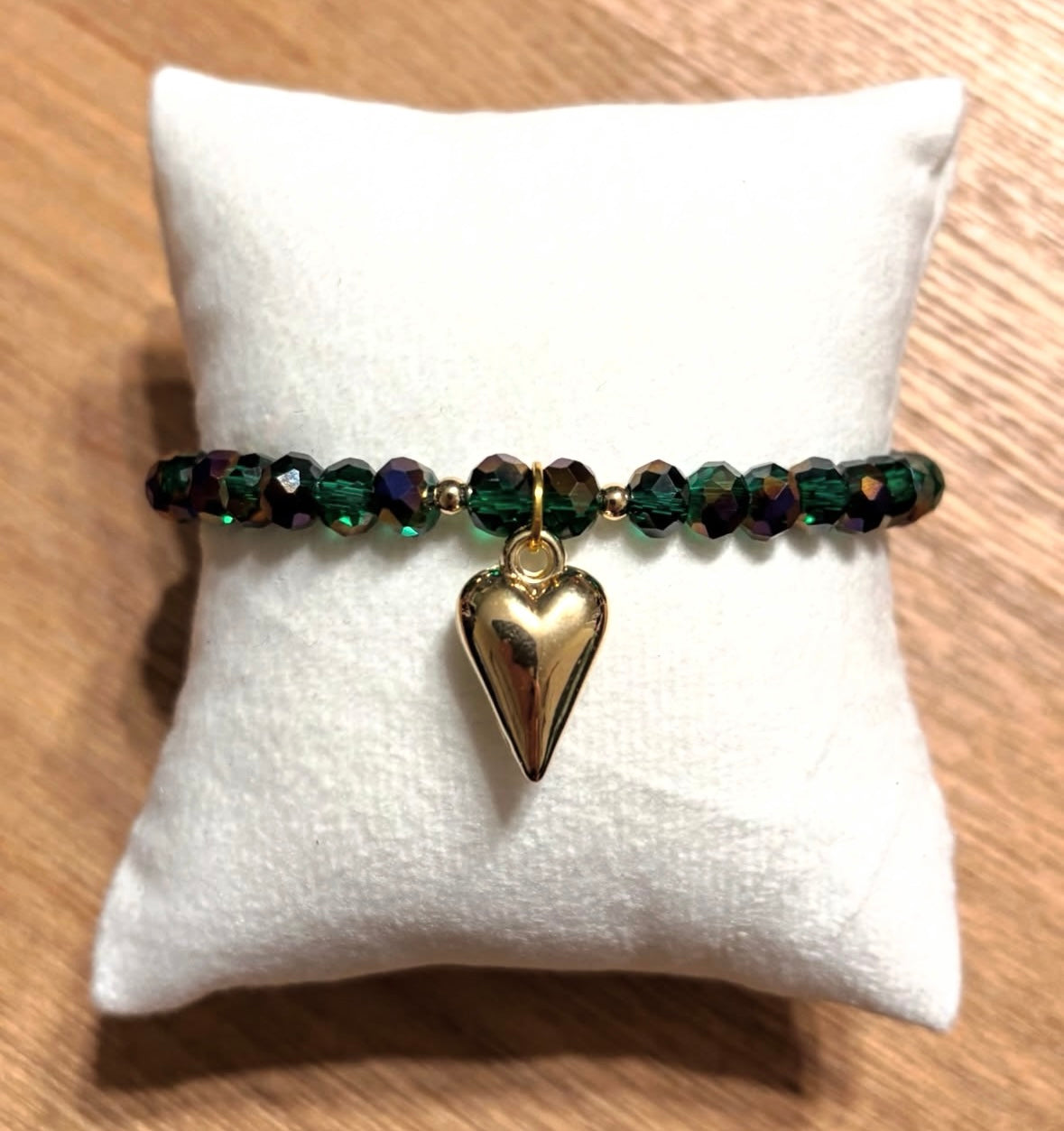 Green bracelet with heart pendant and gold details