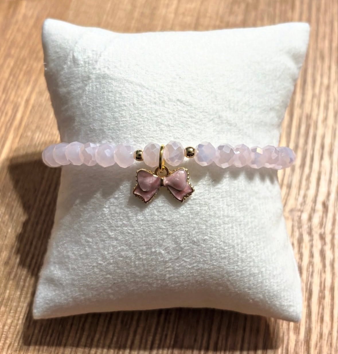 Pink bracelet with bow and gold details