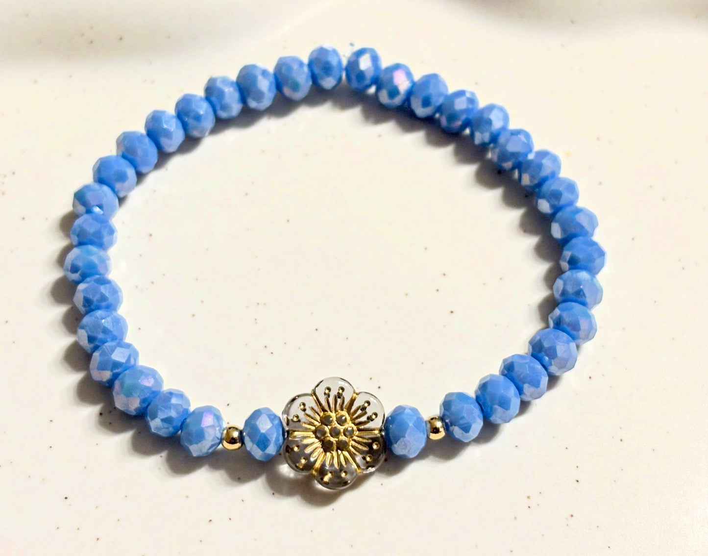 Armband blau mit Blume und goldenen Details
