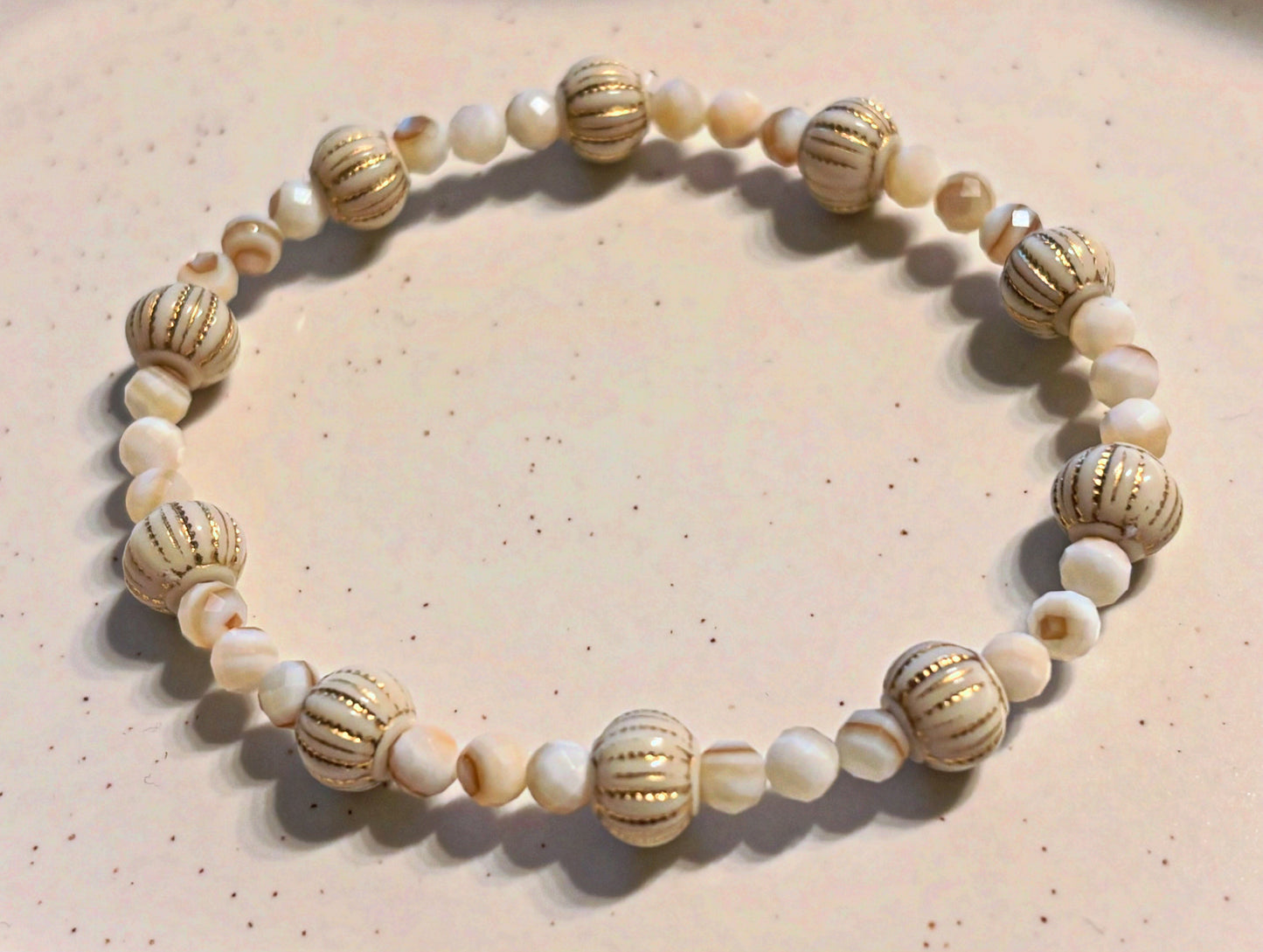 Armband aus natürlichen Muschelperlen und goldenen Details