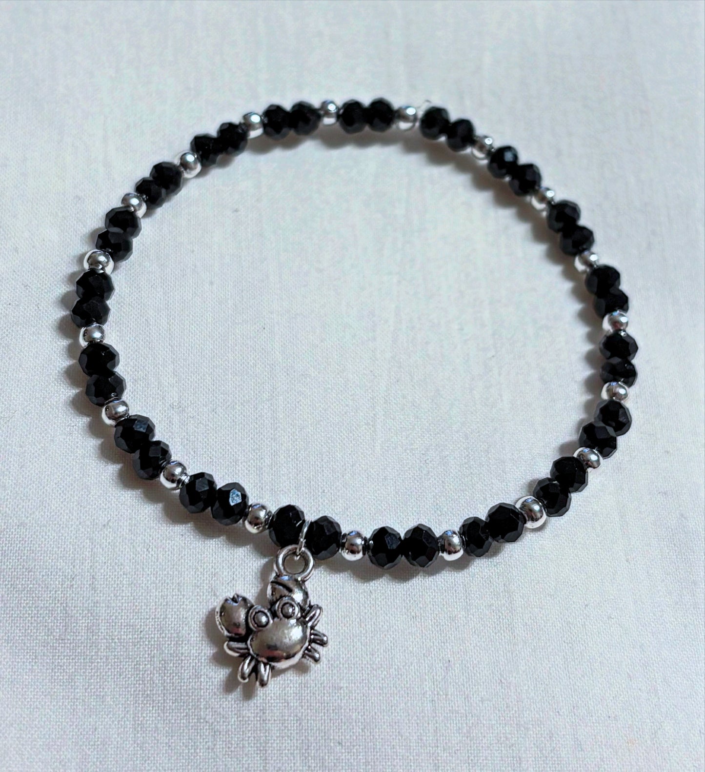 Armband schwarz-silber mit kleinem Krebs Anhänger