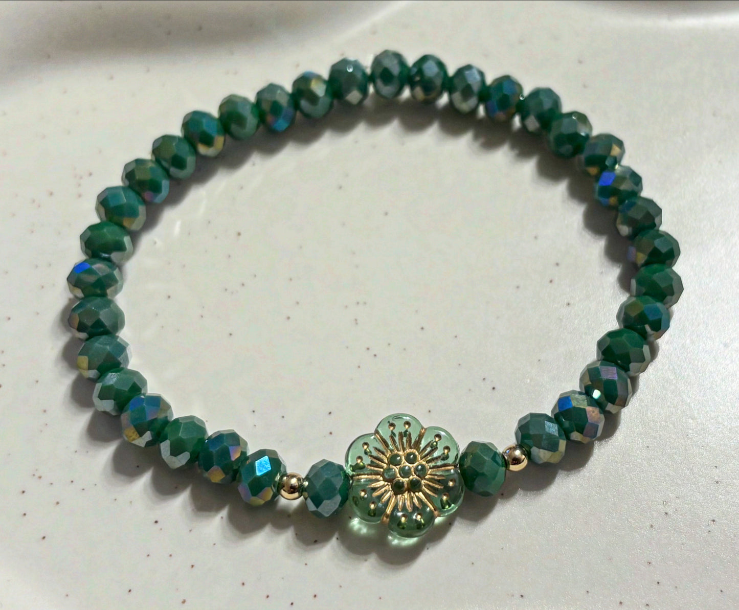 Armband grün mit Blume und goldenen Details