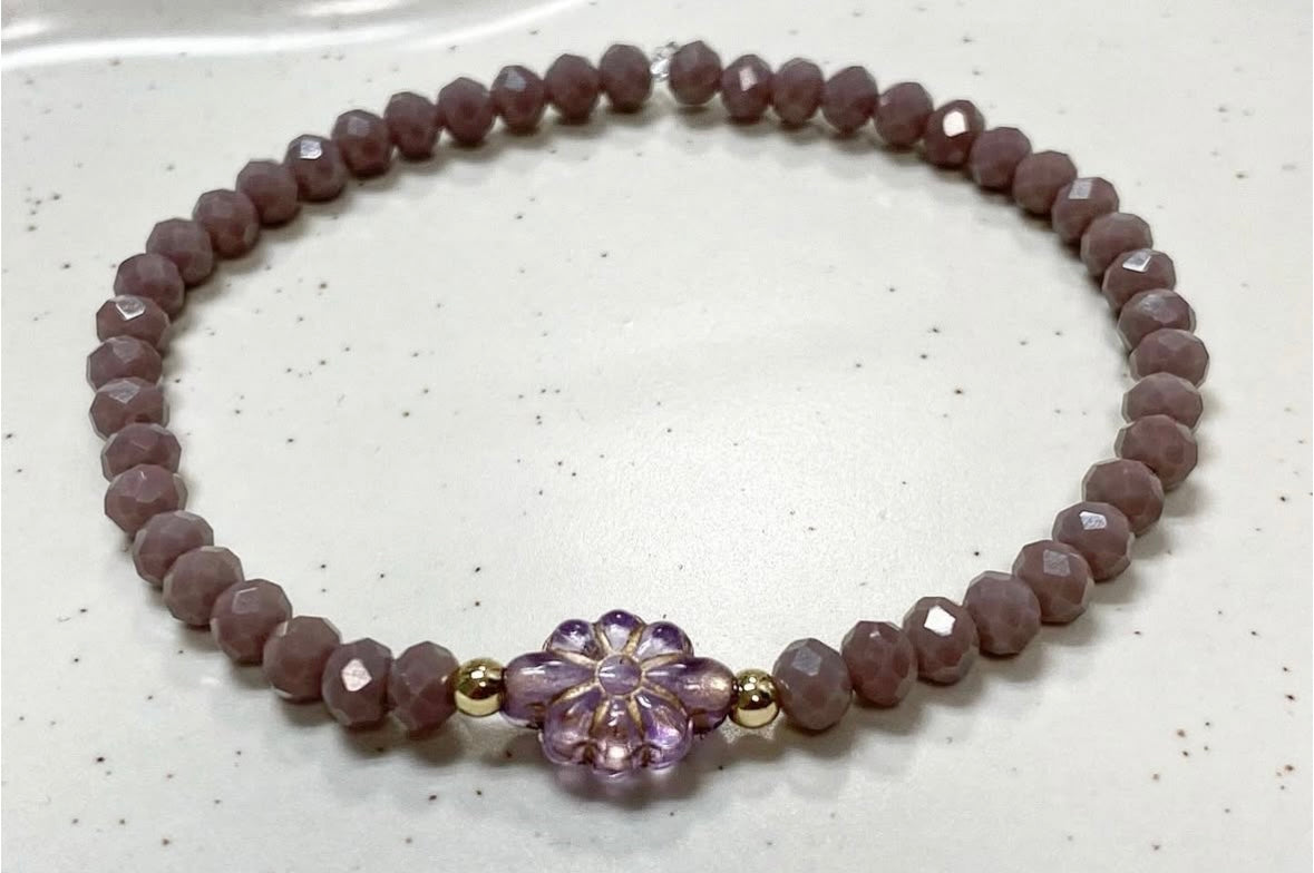 Armband in lila Farben mit goldenen Details