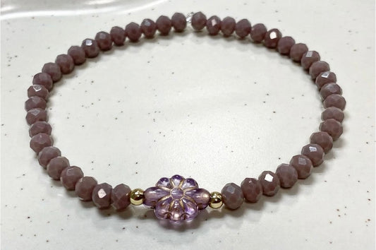 Armband in lila Farben mit goldenen Details