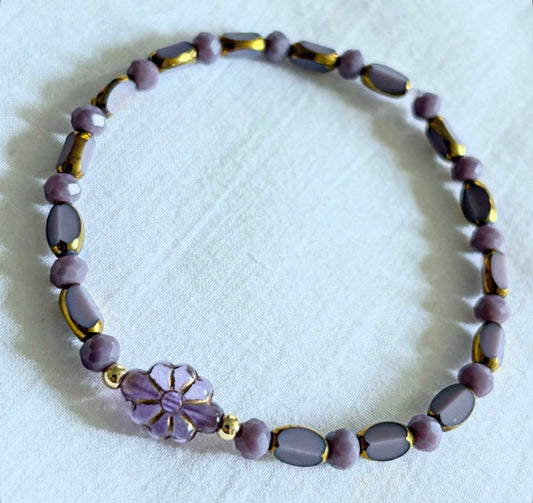 Armband violett mit Blume und goldenen Details