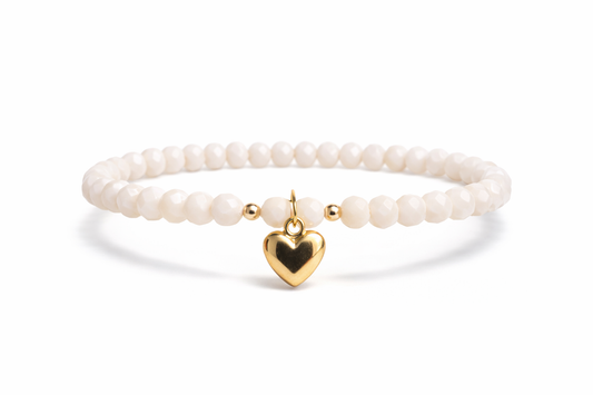 Cream-colored bracelet with heart pendant and gold details