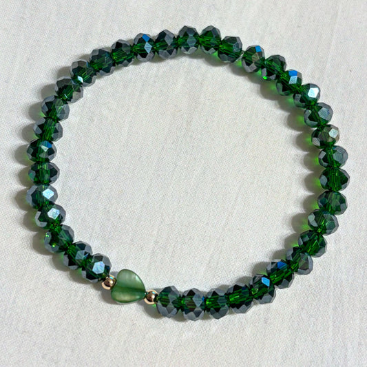 Armband grün mit herzförmiger Muschelperle und goldenen Details