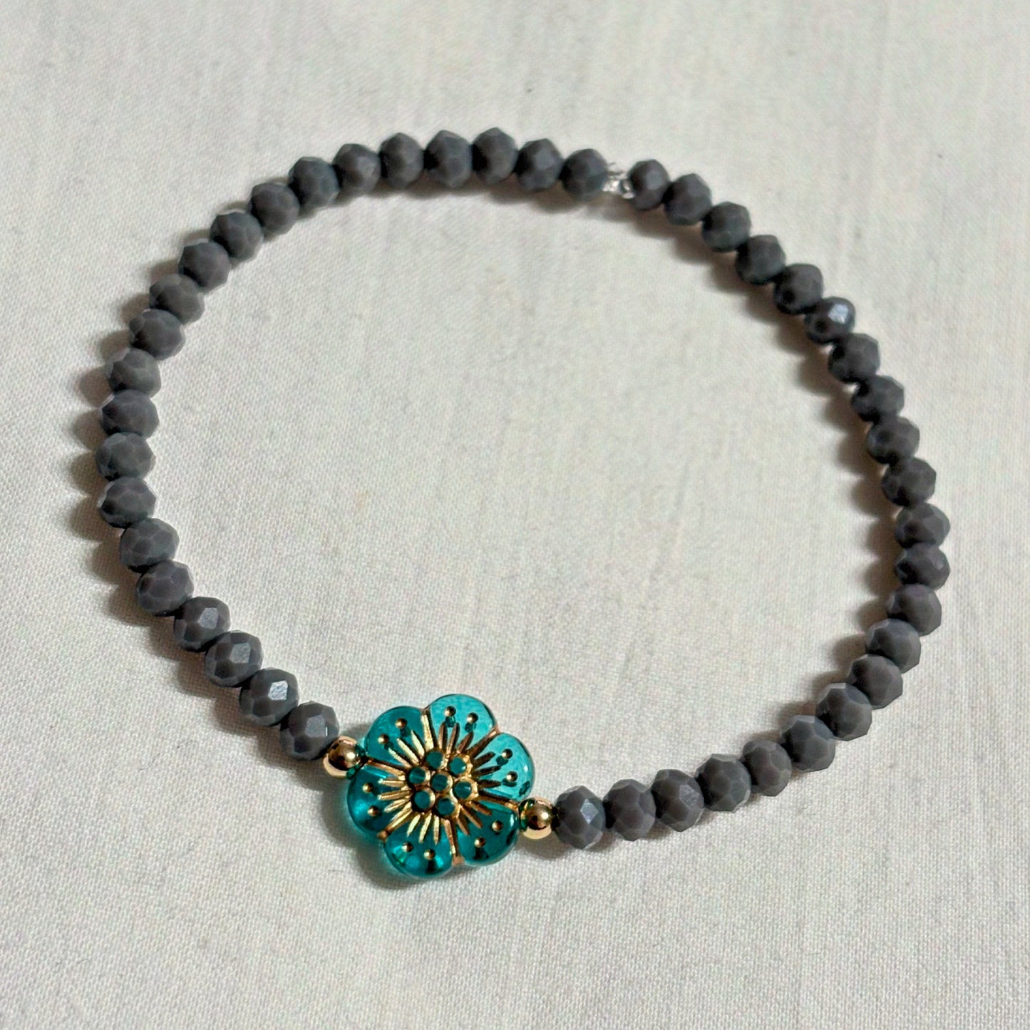 Armband grau mit Blume und goldenen Details