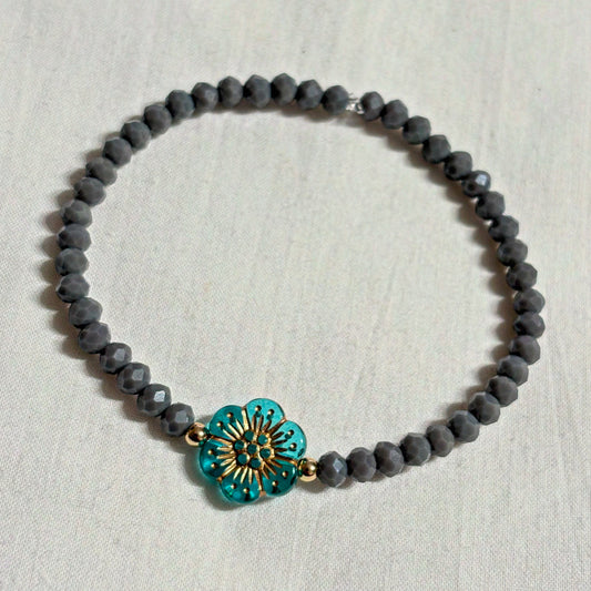 Armband grau mit Blume und goldenen Details